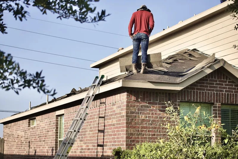 Professional roofer working on a residential roof in West Warwick